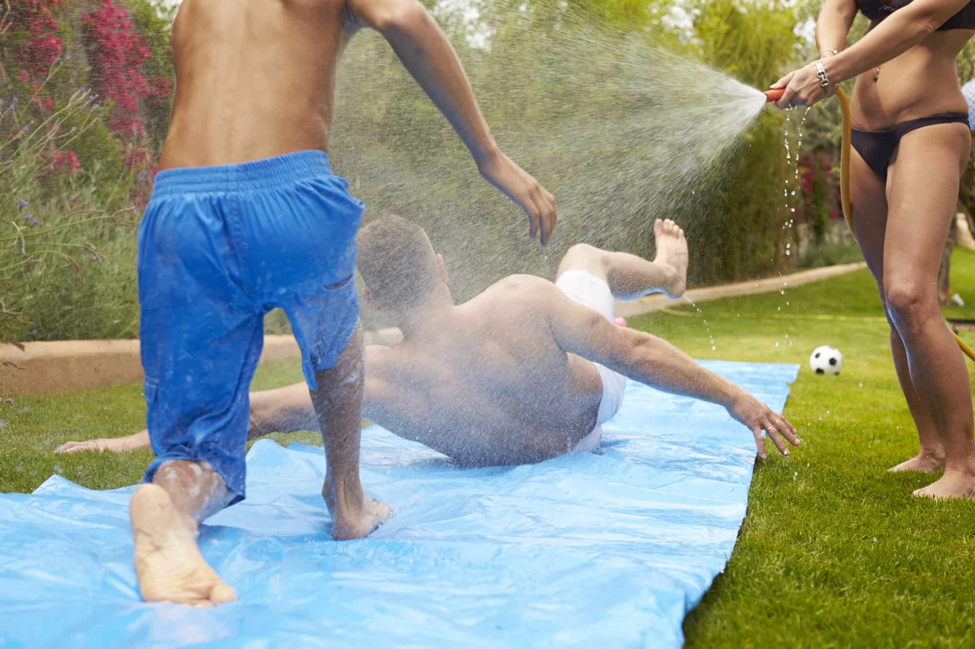 adults enjoying this outdoor water slide