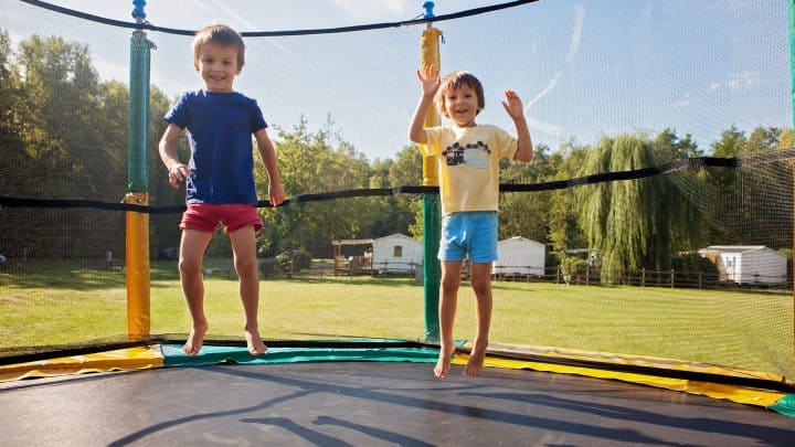 brothers jumping on an above-ground trampoline